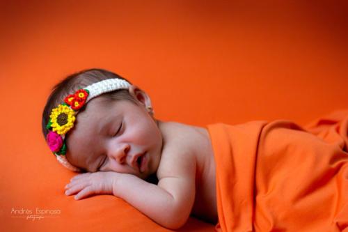 Newborn - Bebe durmiendo en fondo naranja